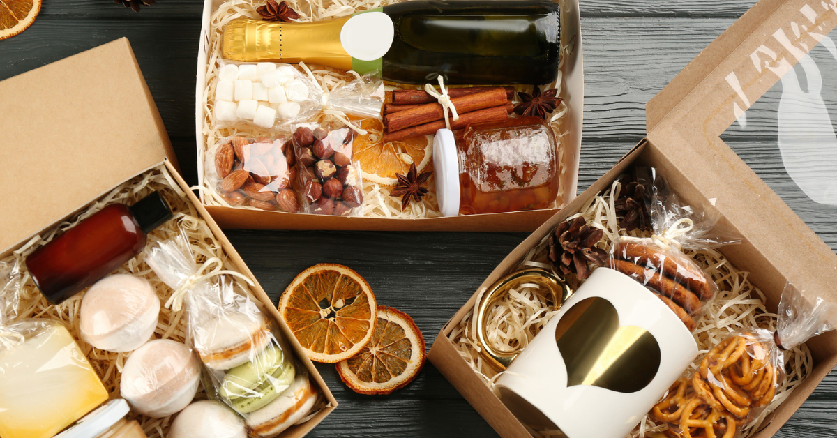 Stylish gift sets on grey wooden table, flat lay.